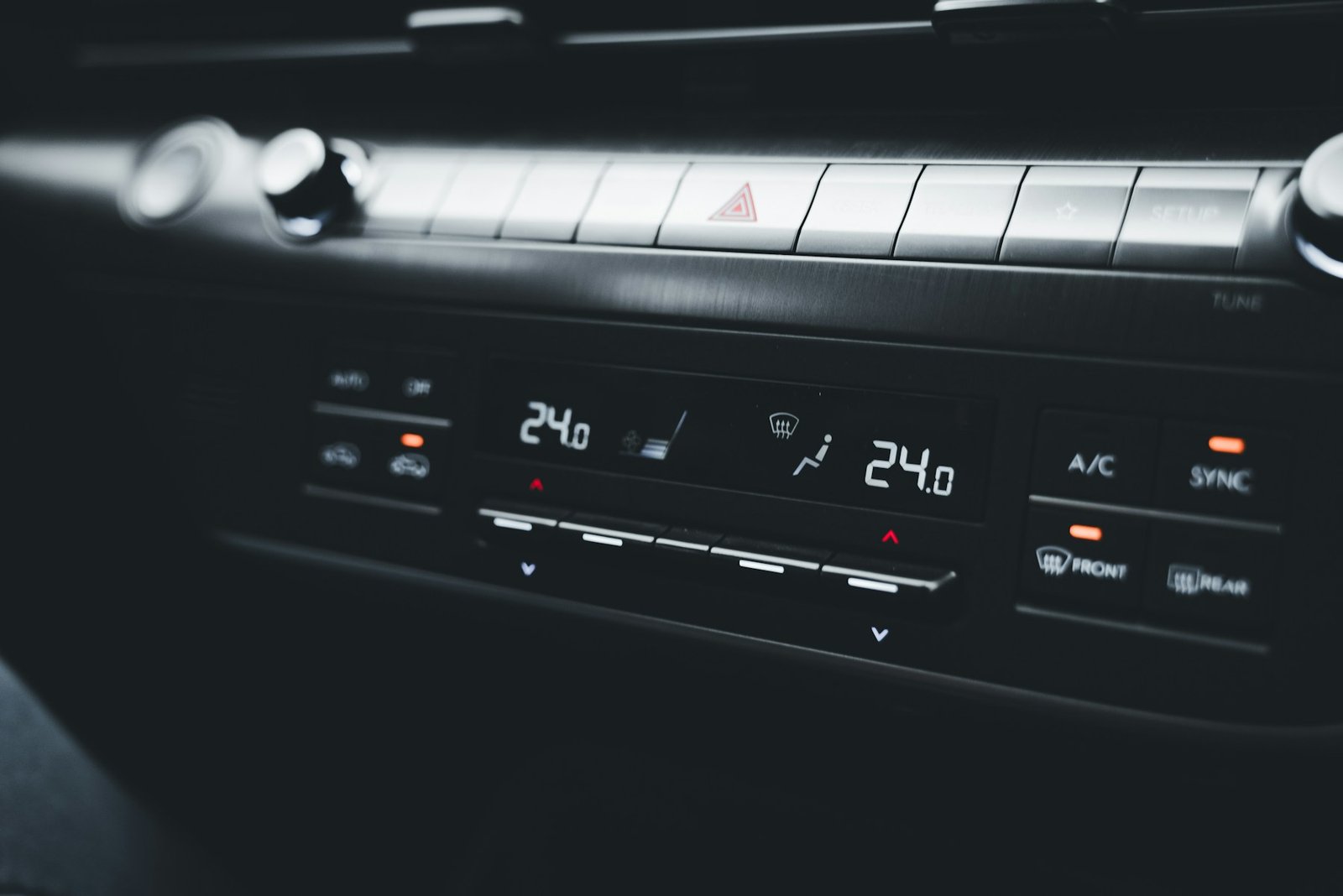 Close-up of car climate controls showing temperature, air conditioning and windshield defrost settings