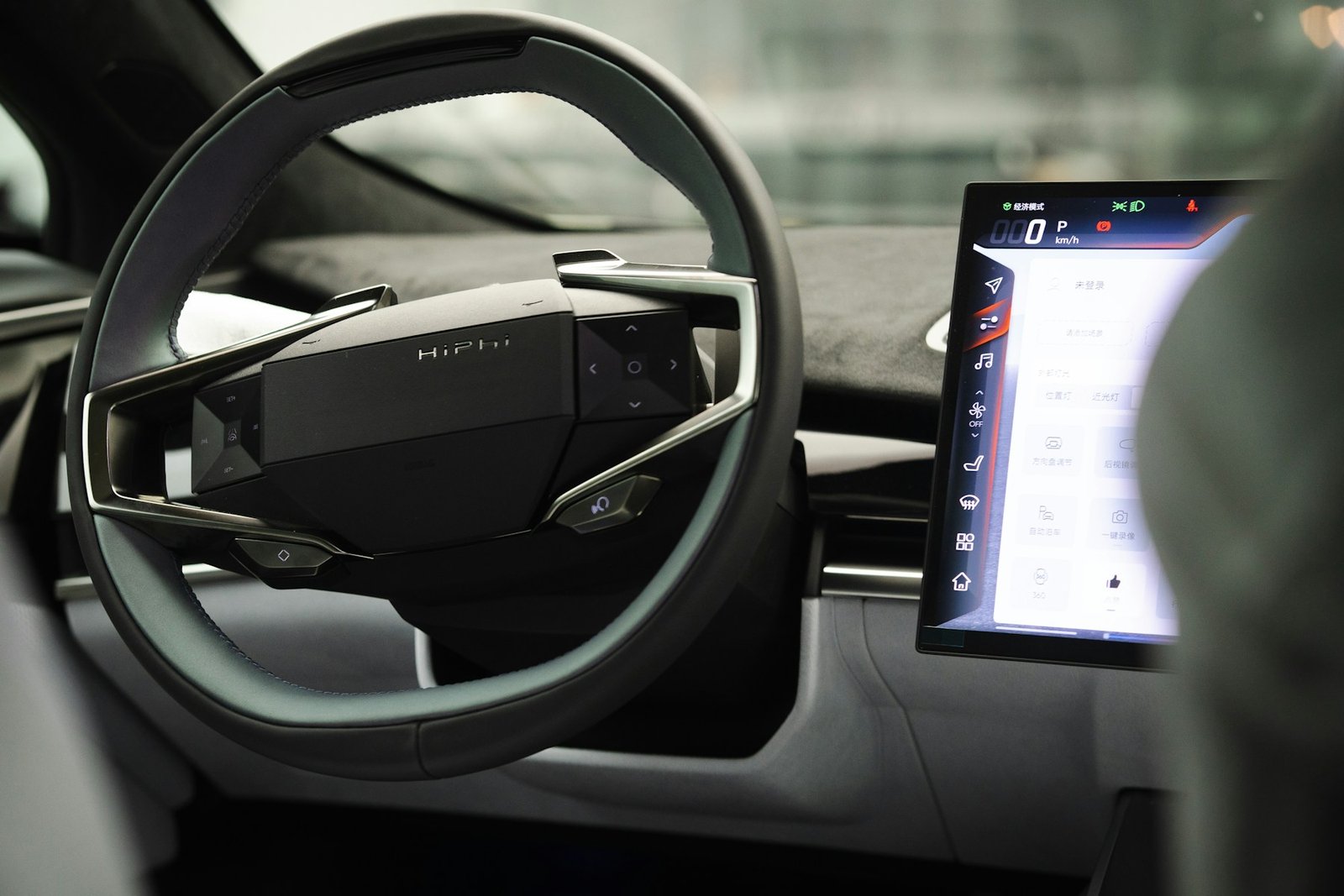 Electric vehicle steering wheel and central dashboard display inside a parked car