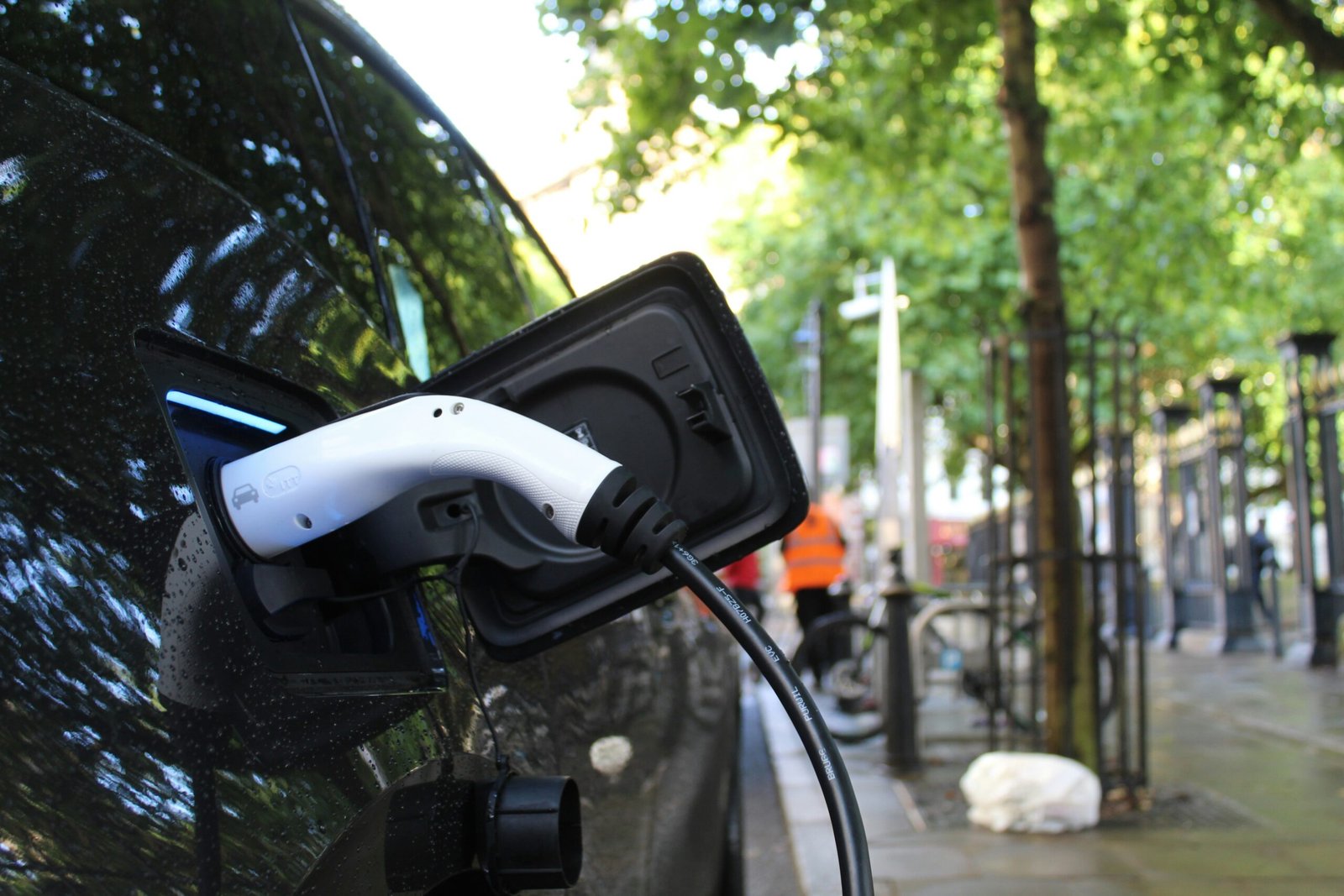 Electric car connected to a public charging station in an urban setting