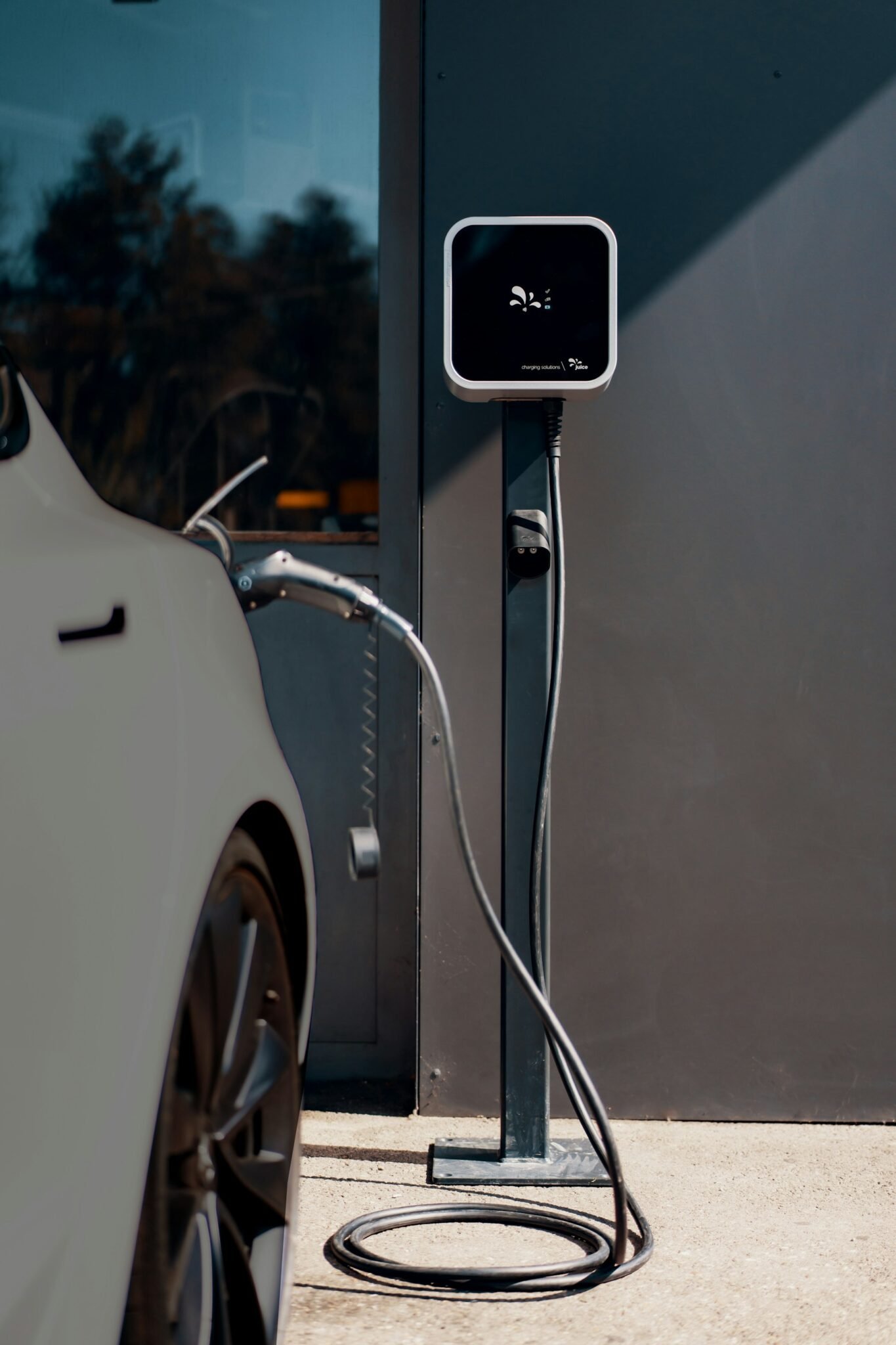 Electric vehicle wheel and charging cable at a public charging station